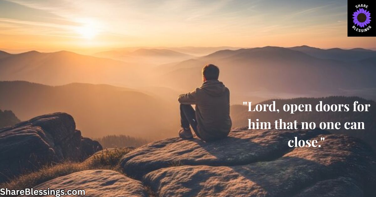 Man sitting alone on mountain peak overlooking sunrise